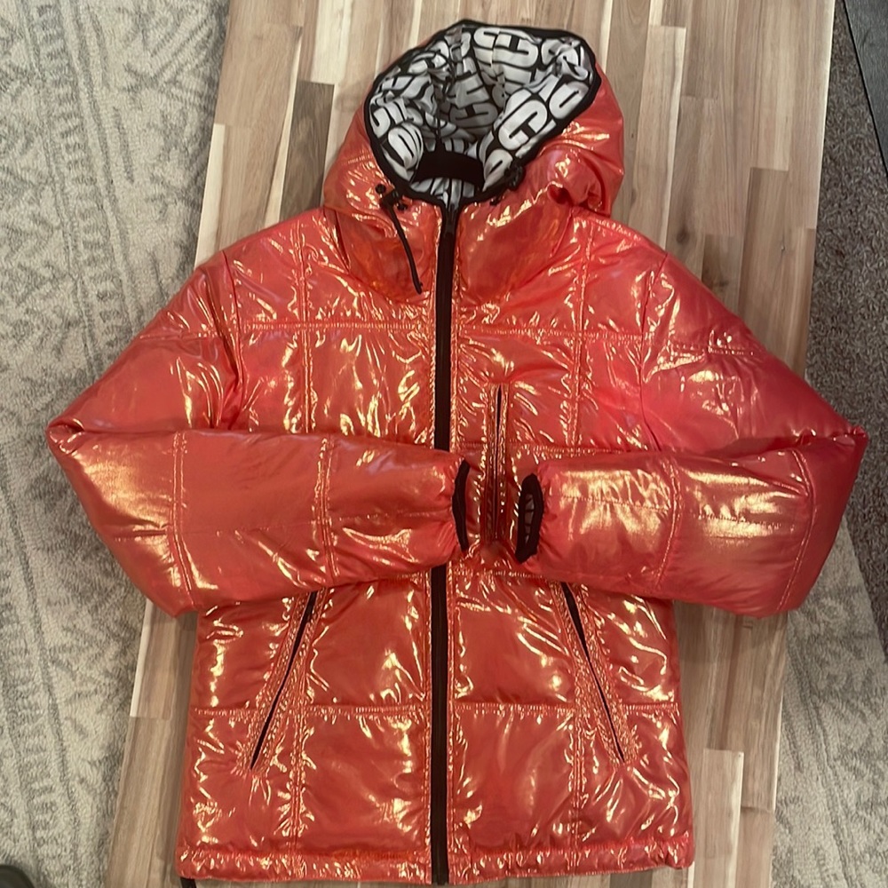 Pink/peach iridescent. It’s reversible side is black and white joyrich writing.